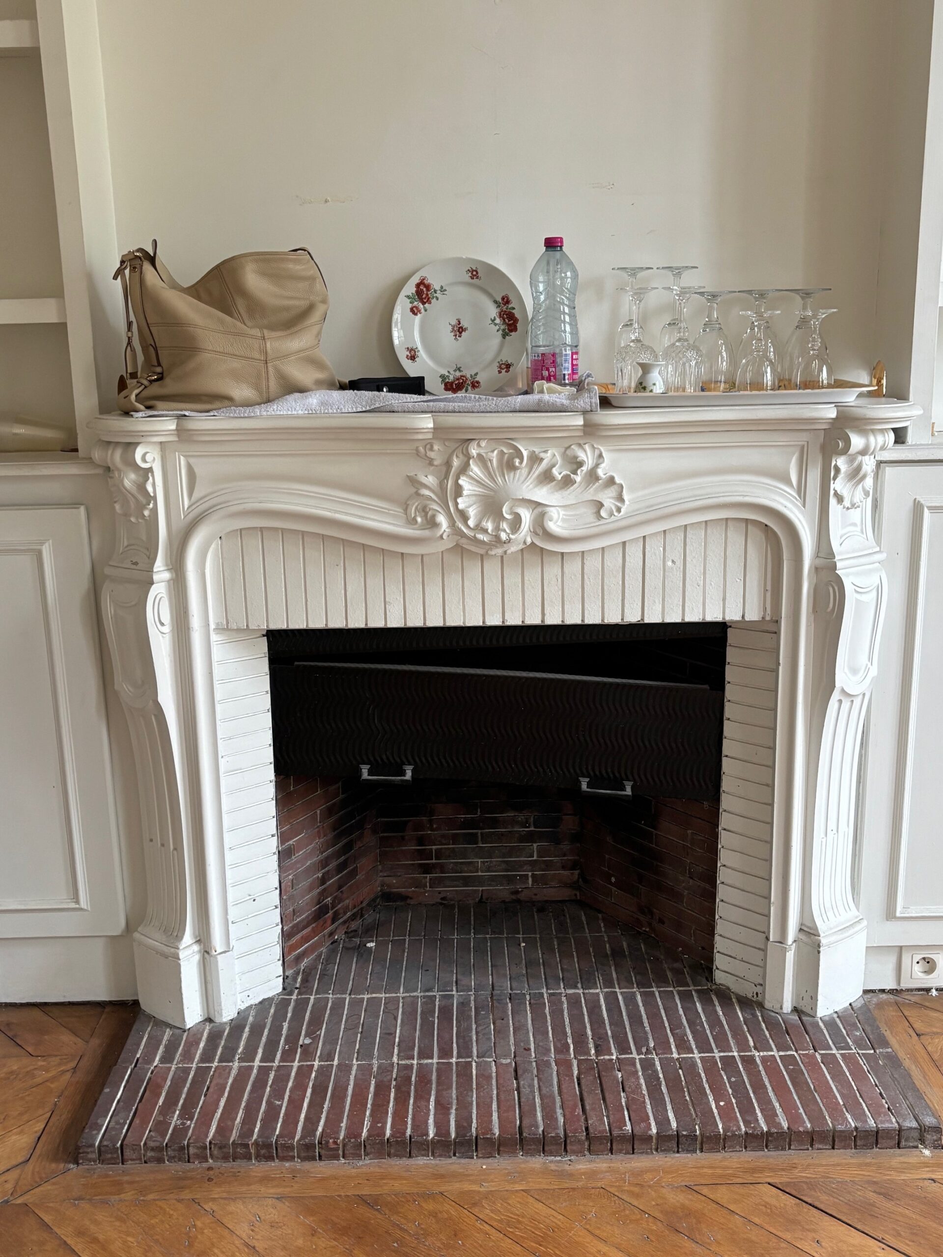 Achat d'une cheminée ancienne Louis XV en marbre de Carrare, vue de face montrant les coquilles sculptées sur le bandeau de style rocaille.